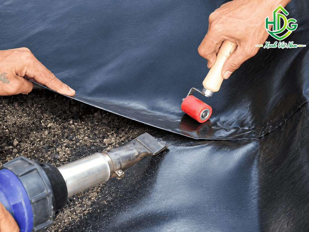 Gia cố chống rò rỉ tại vị trí cổ ống xuyên bạt HDPE bằng máy hàn cầm tay và đai siết inox.